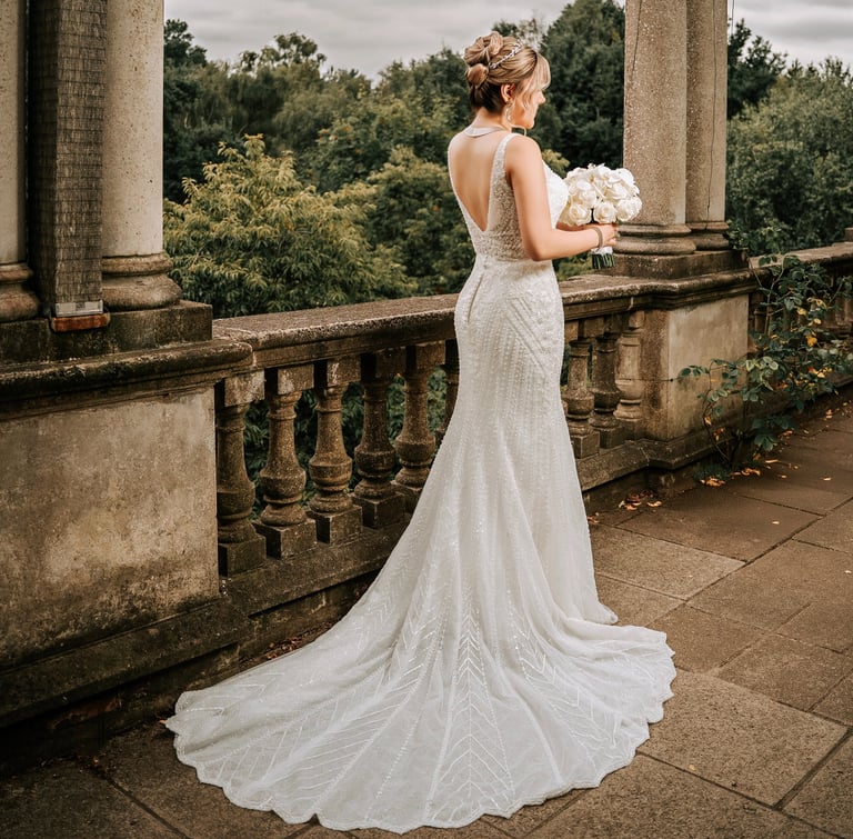 Bride holding a bouquet with her dress elegantly spread on the floor, wedding photography