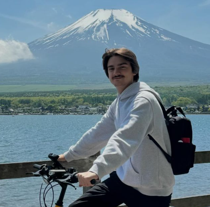 a man riding a bicycle with a backpack on it