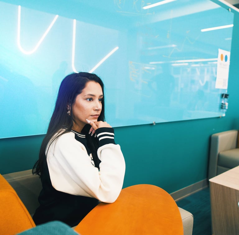a guide gal and woman sitting in a chair in a room