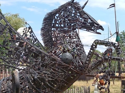 A large scrap metal sculpture of a winged pegasus horse made from recycled iron parts.