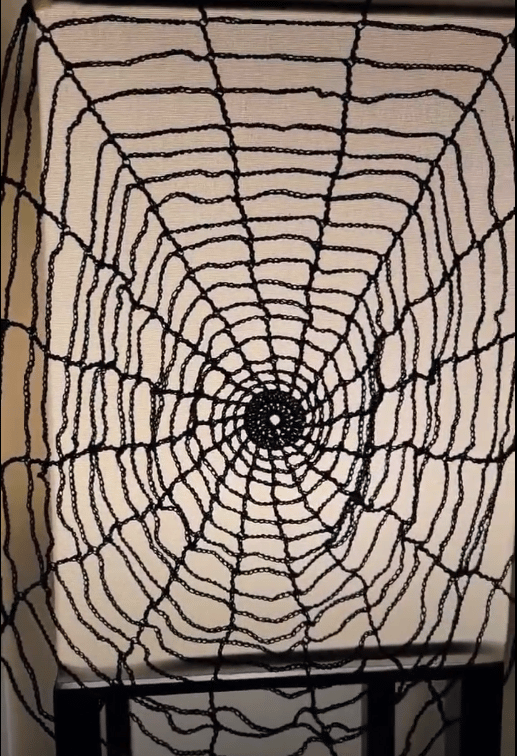 a black crochet spider web