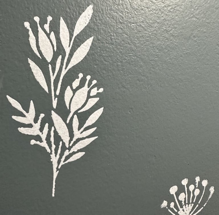White floral wall stencil over custom grey-blue paint in half bath