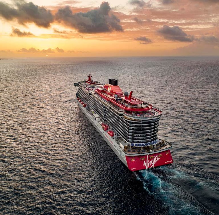 Virgin Voyages cruise ship sailing on the ocean into the sunset
