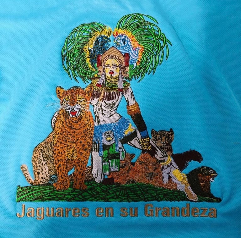 Aztec warrior embroidery with jaguar on a blue jersey featuring Jaguares en su Grandeza text.