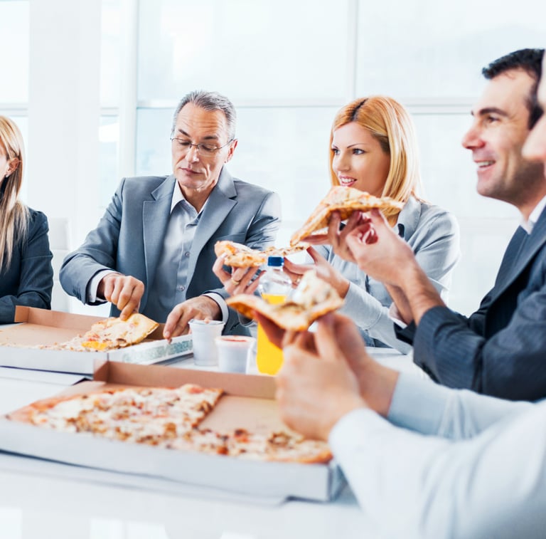 Un groupe d'employés en costume d'affaires mangent une pizza ensemble pendant une pause déjeuner dan