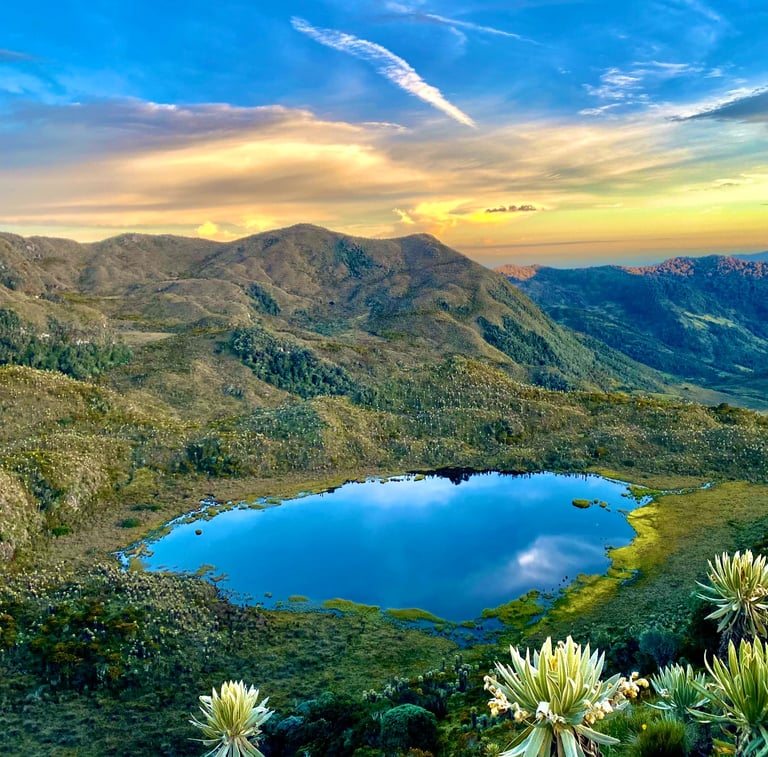 Atardecer en páramo con laguna Vancouver y el Nevado del Tolima al fondo y cielo dorado
