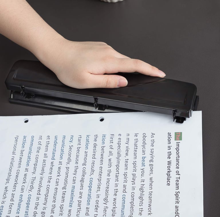 Black Amazon Basics 3-hole paper punch with 10-sheet capacity and easy-clean chip tray