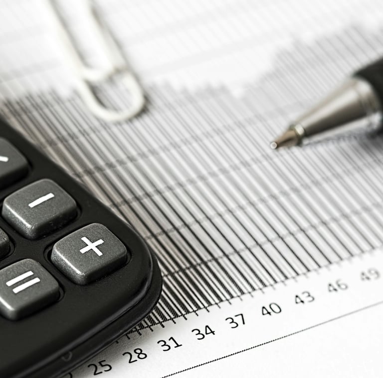 Calculator and pen on financial charts for accounting and budget planning analysis.