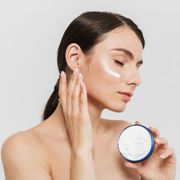 woman mosturizing her face