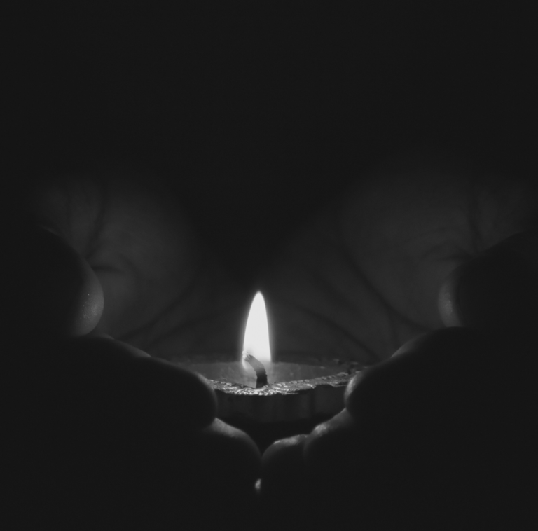 Hands holding a diya lamp