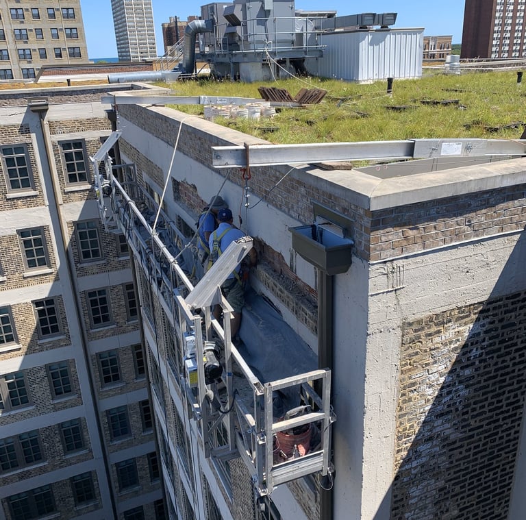Rooftop masonry and concrete repair work on a commercial building's parapet wall.