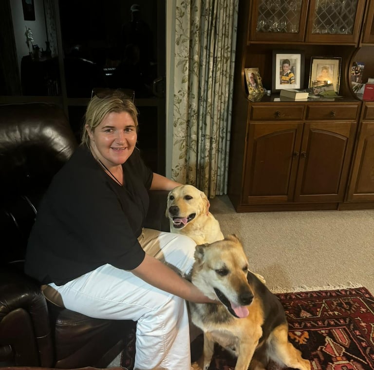 a woman sitting on a couch with two dogs