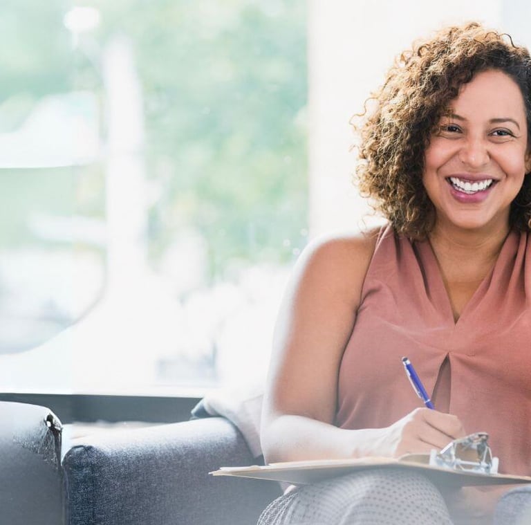 a woman sitting on a couch with a notebook and pen