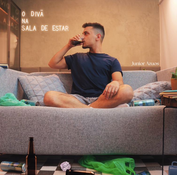 a man sitting on a couch drinking a beer