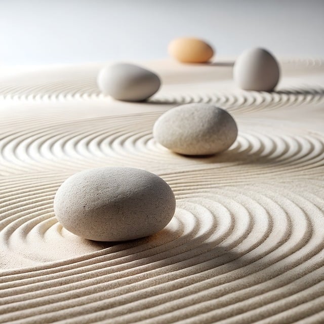 Smooth river stones on a Japanese zen sand garden with raked circular patterns for meditation.