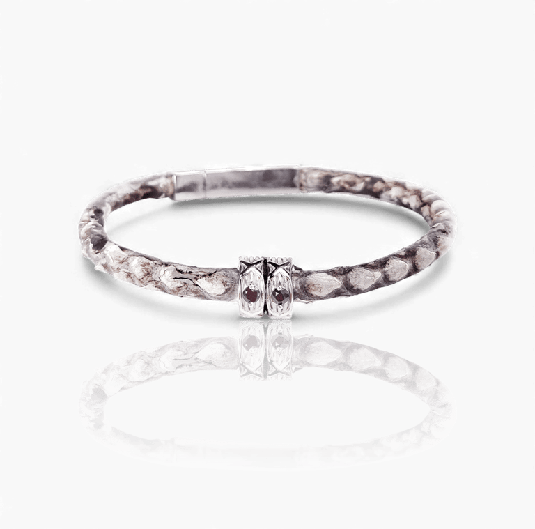 Handcrafted python skin leather bracelet with silver details and garnet gemstones on a white background.