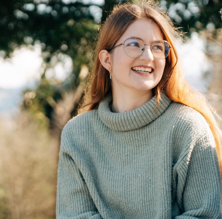 Svenja Ricchiuti, Grafikerin bei SRdesign, draussen sitzend.