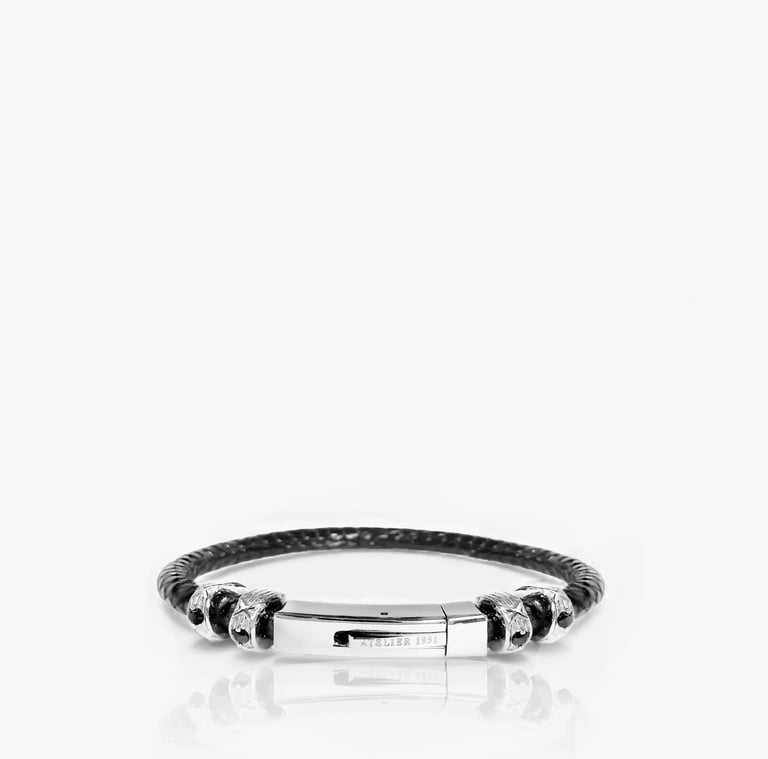 Unisex black braided leather bracelet with a polished silver clasp and decorative charms.
