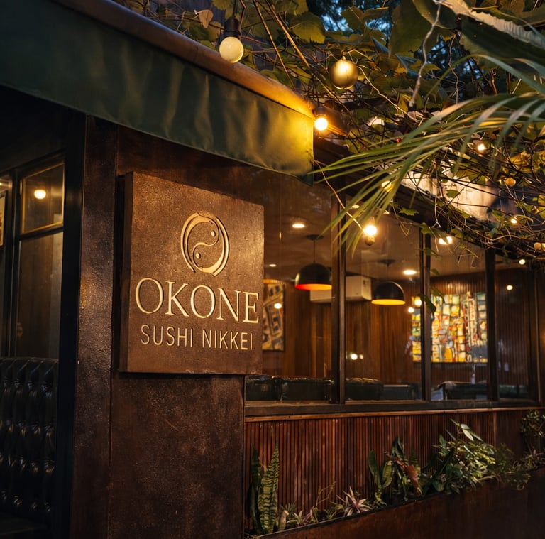 Close da placa de madeira com o logotipo dourado do Okone Sushi Nikkei na fachada do restaurante
