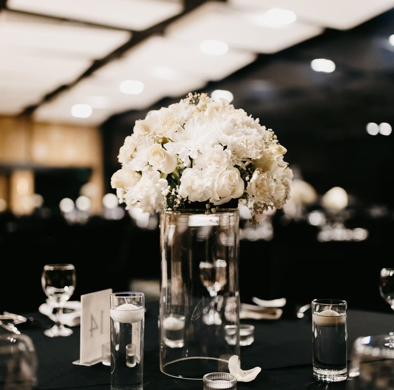 a table with a vase filled with white flowers