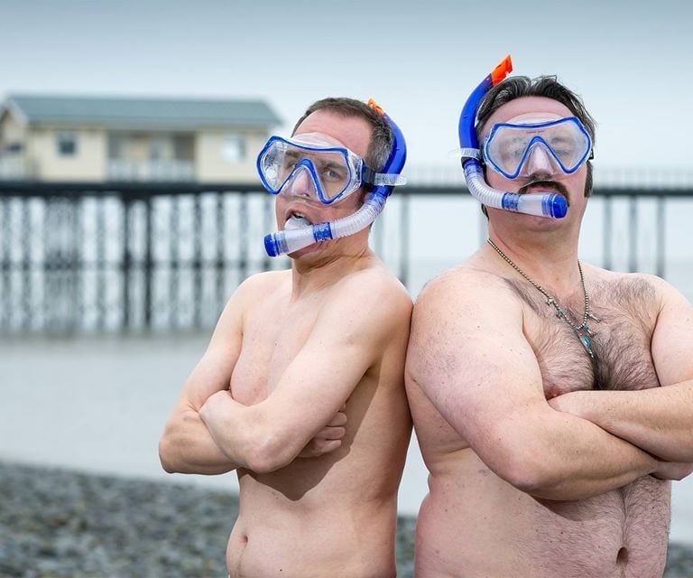 The Unexplainers posing in swimming trunks, weaking masks and snorkels