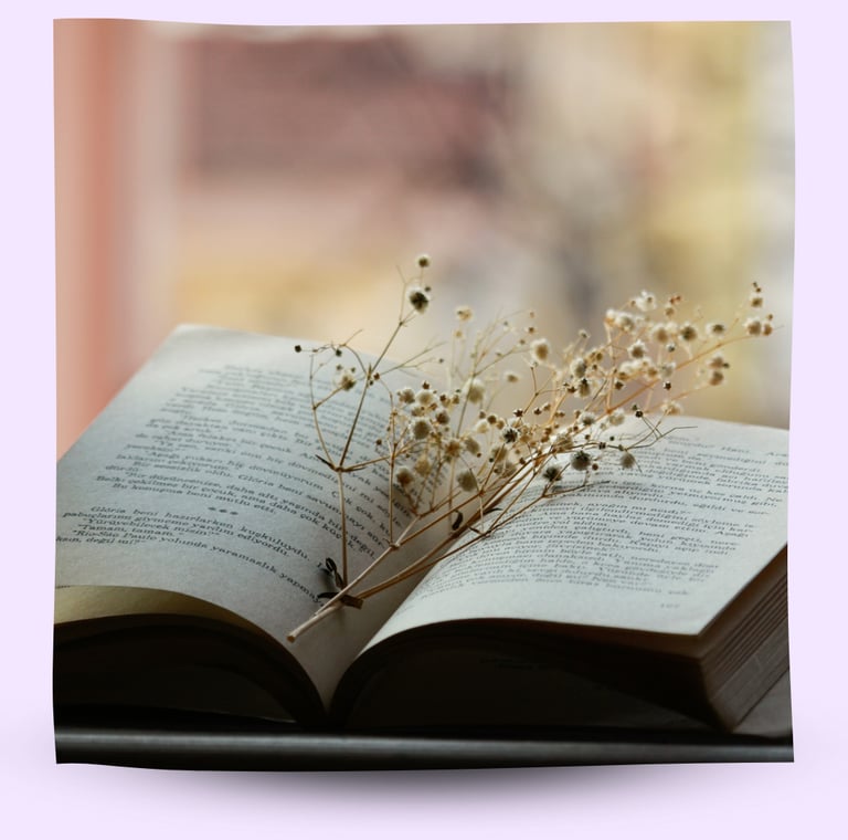 An open book with dried flowers in the middle.