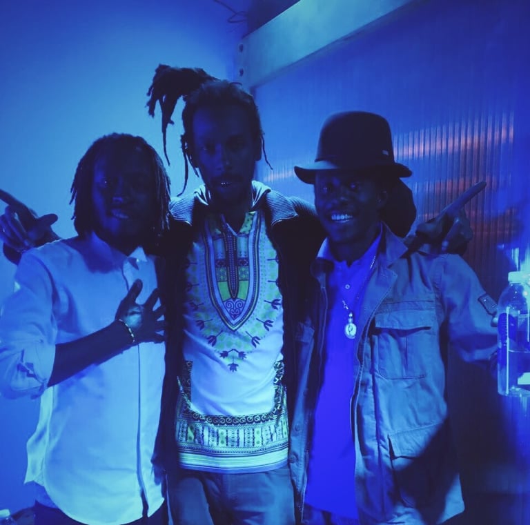 three men standing next to each other in a room