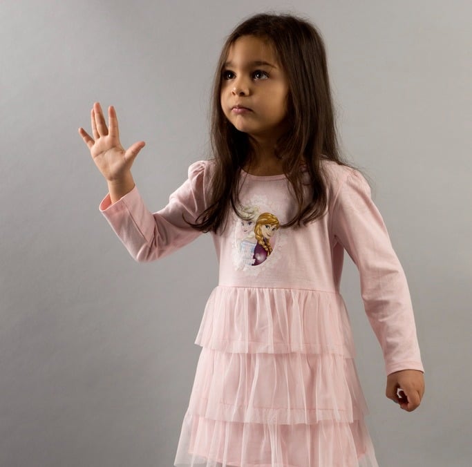 a young girl in a pink dress and tight socks