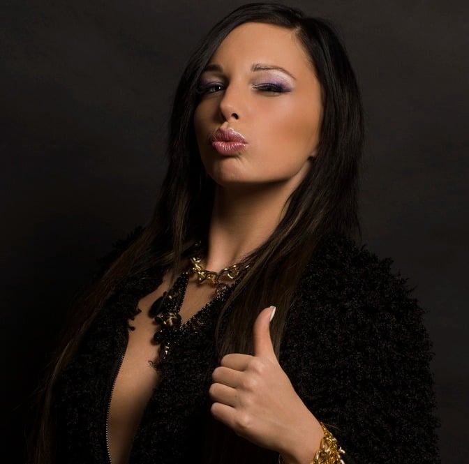 a beautiful woman with long hair and a black jacket wearing necklace