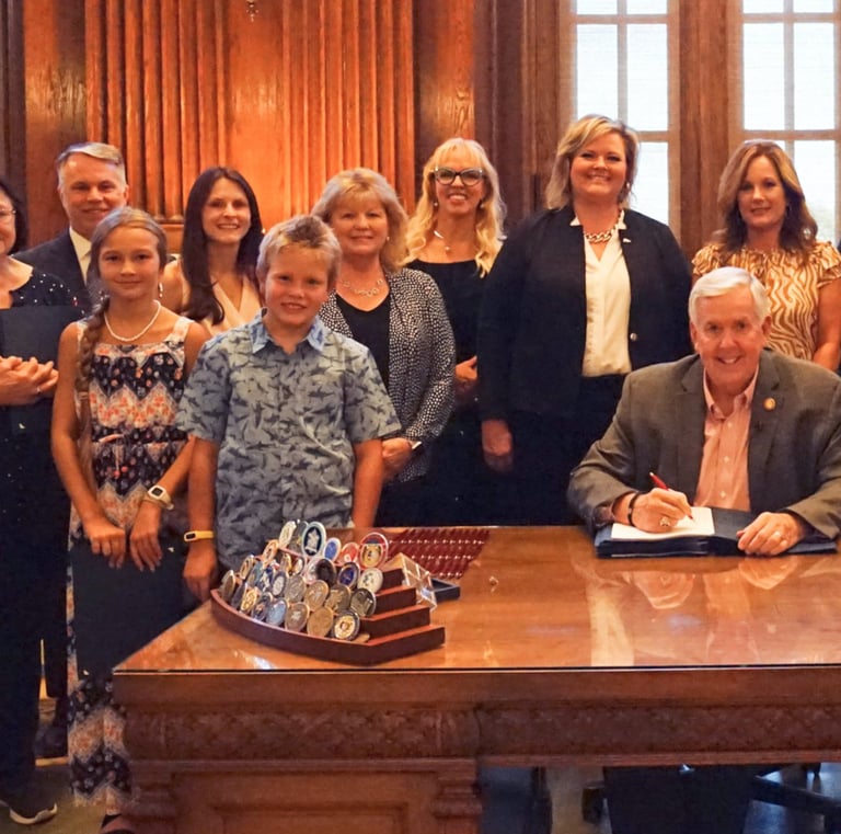 Large group of people in the governor's office, posing for a picture