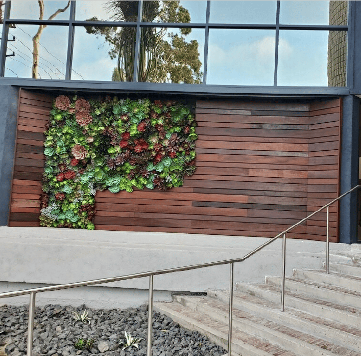 a building with a wall of plants on the side of it