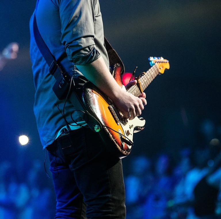 person playing electric guitar in front of audience