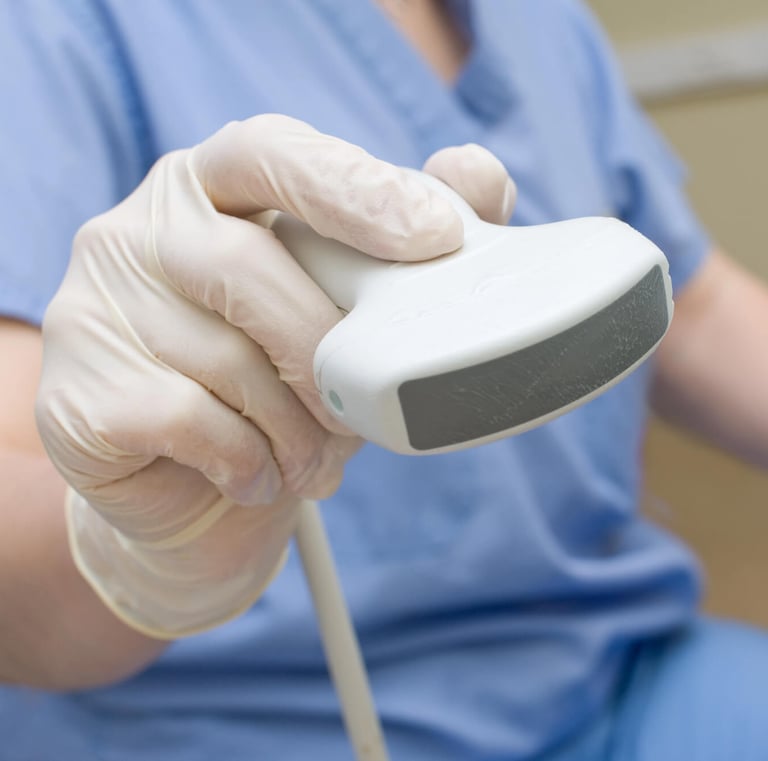 a person in a blue scrub suit and gloves holding a ultrasound tool