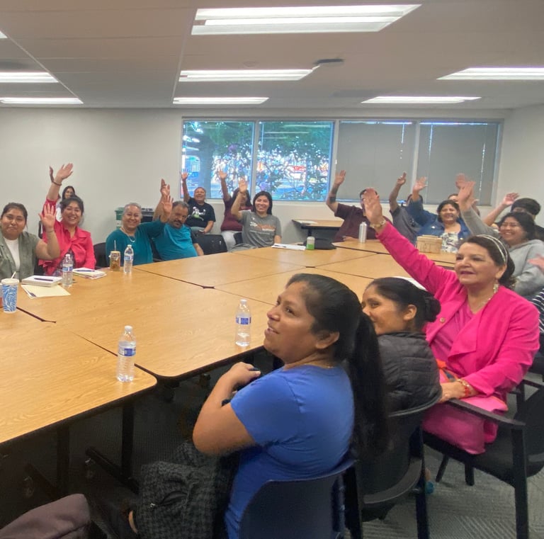 People around a table raising their hands