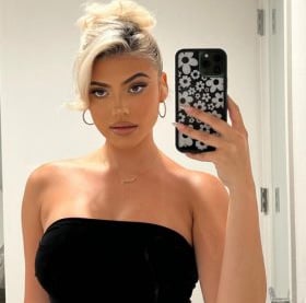 a woman in a black dress is taking a selfie