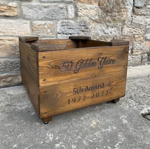 a wooden planter with personalised engraving on the front