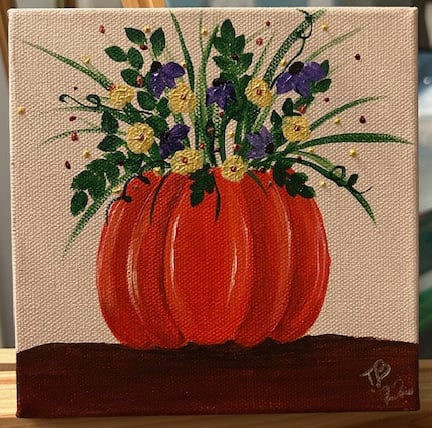 Yellow and Purple Flowers in a Pumpkin