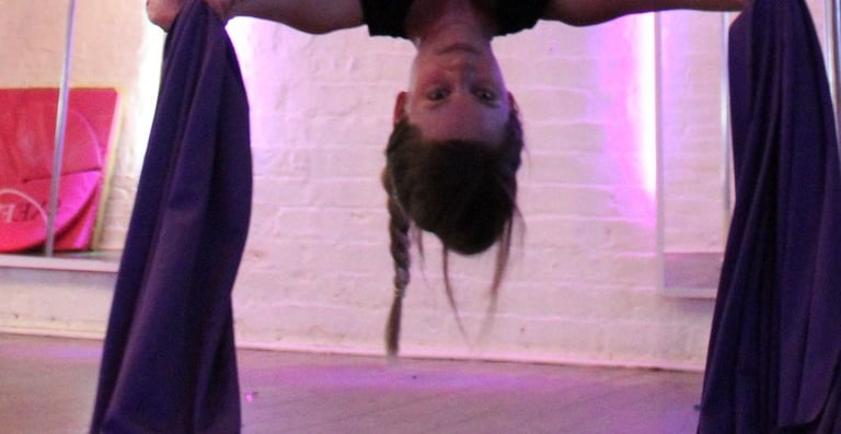 Image of student at Sxefit aerial silks class upside down
