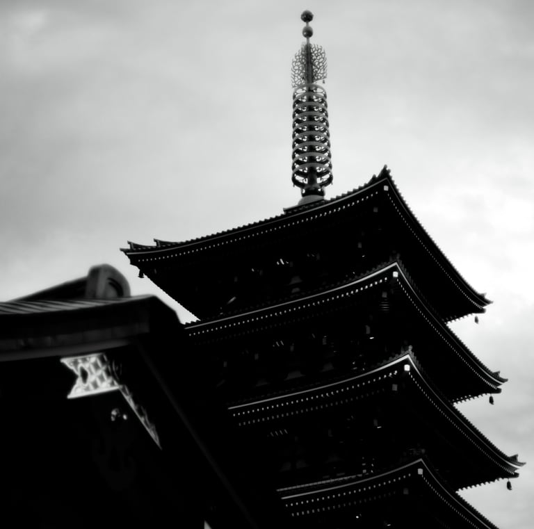a tall pagoda with a clock tower in the background