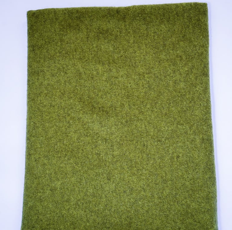 Luxurious dark green yak wolle scarf with soft texture and fringed edges, neatly folded on white.