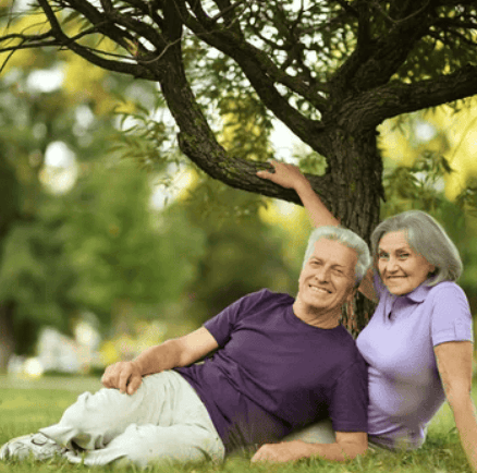 a man and woman sitting on the grass