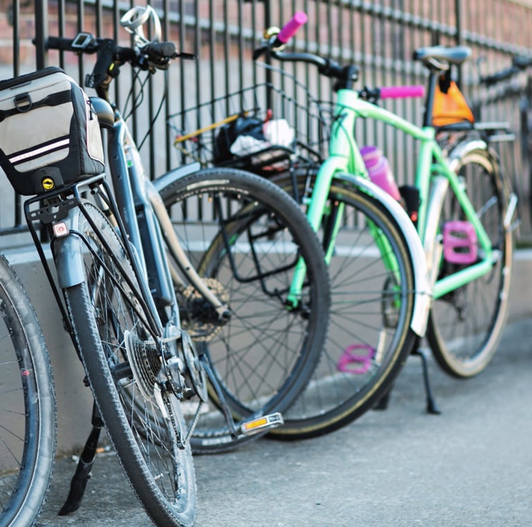 A bunch of bikes leaning up against a fence