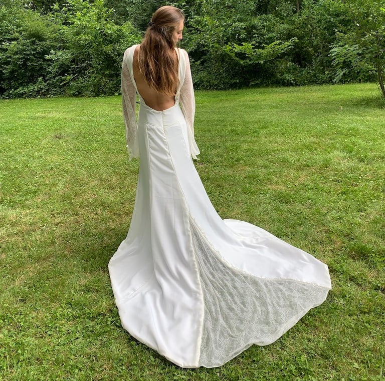 a woman in a white dress standing in the grass
