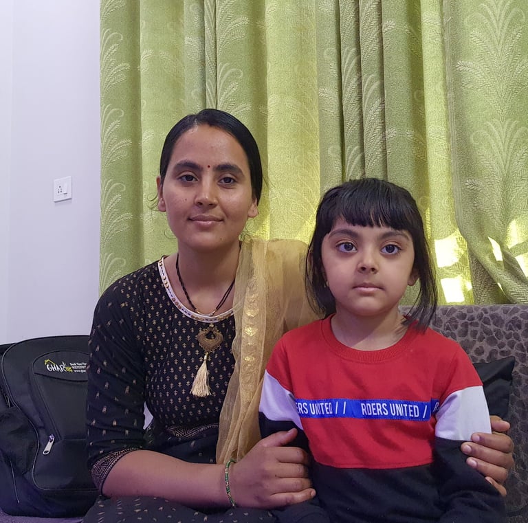 a woman sitting on a couch with her daughter