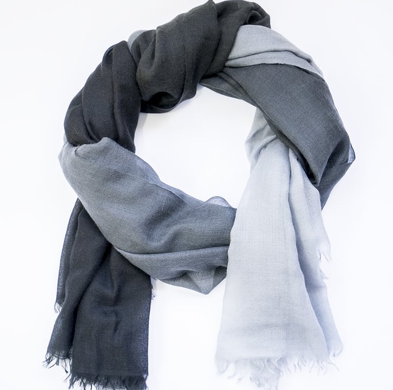 Elegant two-tone scarf with smooth black to grey gradient, styled in a soft circular wrap on white.