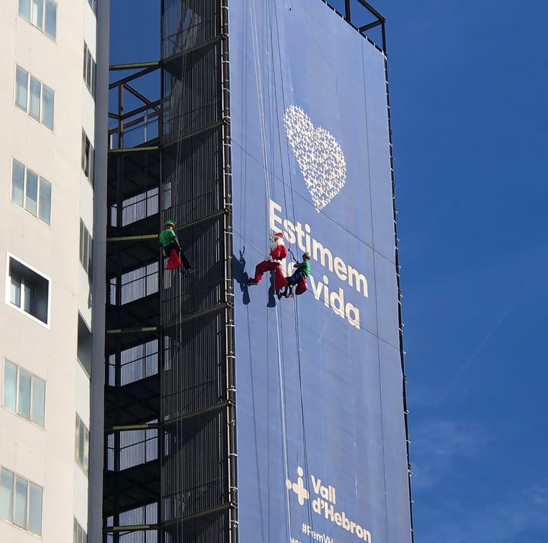 a man on a rope rope with a banner on the side of a building