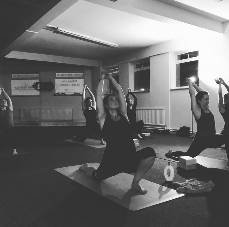 a group of people doing yoga poses in a gym