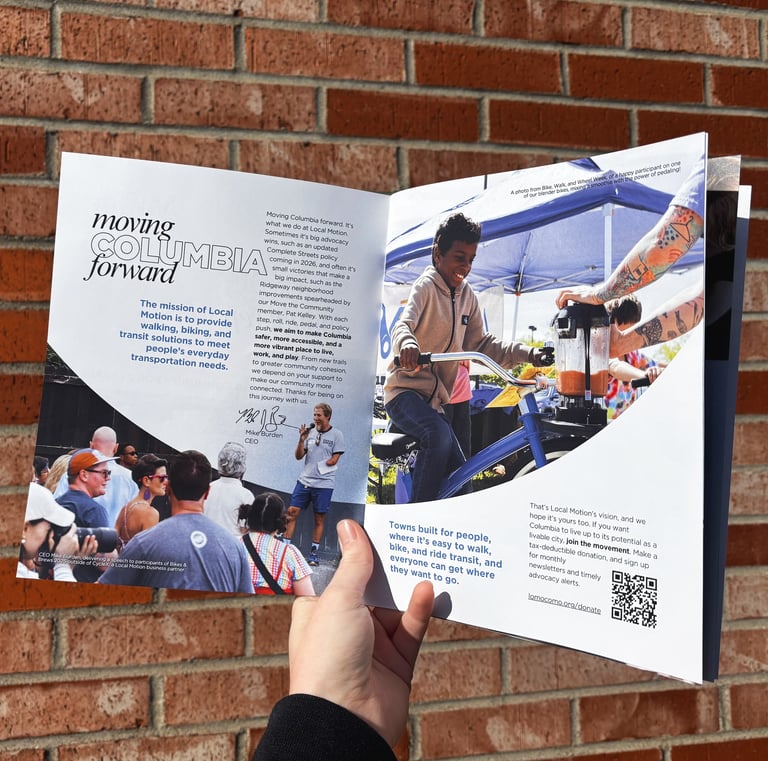 A hand holding open the 2025 Annual Report Booklet