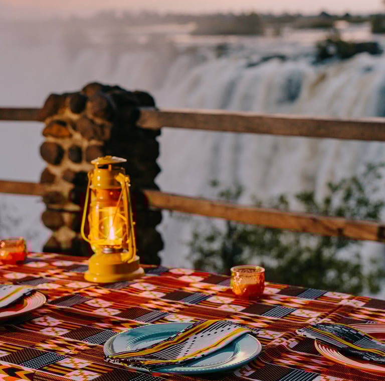 dinner table set up facing the Victoria Falls