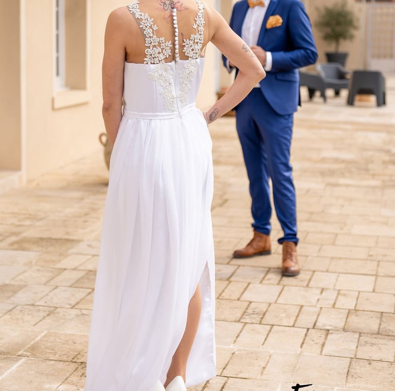 a bride and groom standing in front of a house